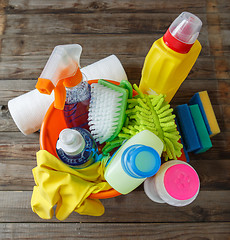 Image showing Plastic bucket with cleaning supplies on wood background