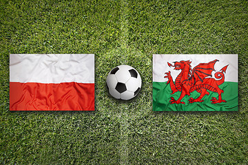 Image showing Poland vs. Wales flags on soccer field