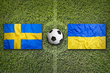 Image showing Sweden vs. Ukraine flags on soccer field