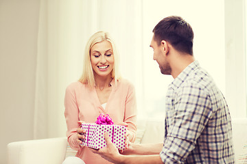 Image showing happy man giving woman gift box at home