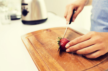 Image showing close up of woman chopping strawberry at home