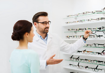 Image showing woman and optician showing glasses at optics store