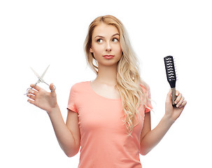 Image showing young woman with scissors and hairbrush