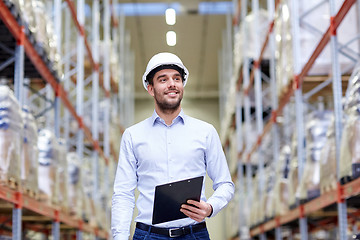Image showing happy businessman with clipboard at warehouse