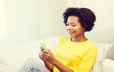 Image showing happy african woman with smartphone at home