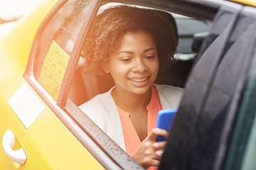 Image showing happy african woman texing on smartphone in taxi