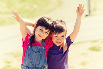 Image showing two happy kids hugging outdoors