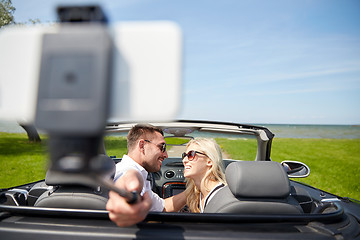 Image showing happy couple in car taking selfie with smartphone