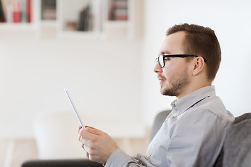 Image showing smiling man working with tablet pc at home