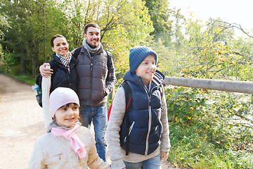 Image showing happy family with backpacks hiking in woods