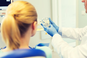 Image showing close up of dentist showing teeth model to patient