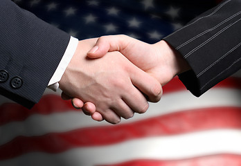 Image showing hand shake and a American flag in the background