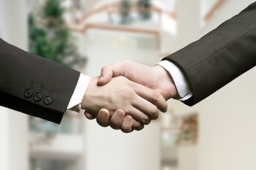 Image showing business hand shake and a office in background