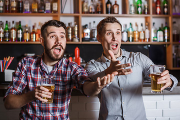 Image showing Young people with beer watching football in a bar