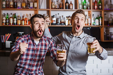 Image showing Young people with beer watching football in a bar