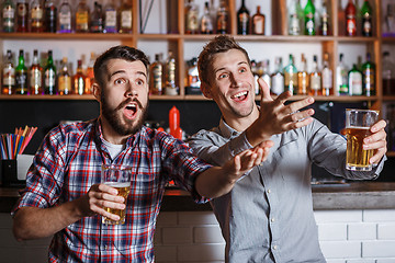 Image showing Young people with beer watching football in a bar