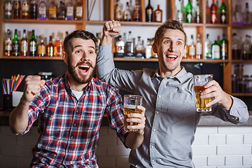 Image showing Young people with beer watching football in a bar