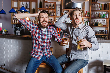 Image showing Young people with beer watching football in a bar