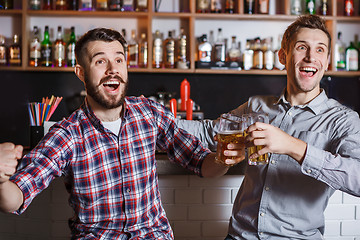 Image showing Young people with beer watching football in a bar