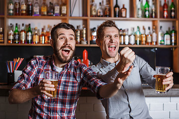 Image showing Young people with beer watching football in a bar