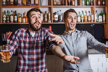 Image showing Young people with beer watching football in a bar