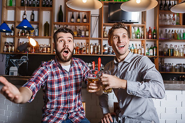 Image showing Young people with beer watching football in a bar