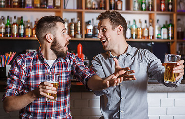 Image showing Young people with beer watching football in a bar