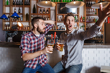 Image showing Young people with beer watching football in a bar