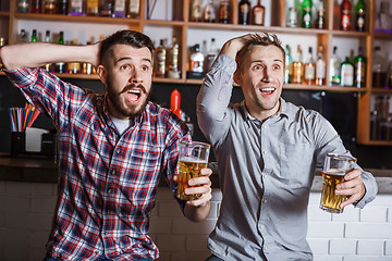 Image showing Young people with beer watching football in a bar