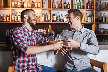 Image showing Happy friends drinking beer at counter in pub