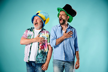 Image showing The two football fans singing the national anthem over blue