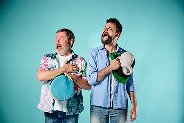 Image showing The two football fans singing the national anthem over blue