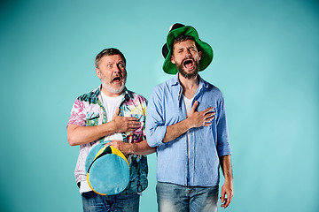 Image showing The two football fans singing the national anthem over blue