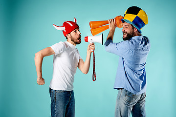 Image showing The two football fans with mouthpiece over blue