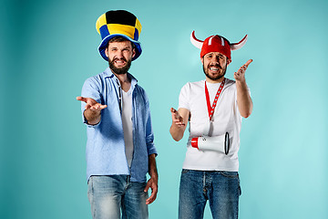 Image showing The two football fans with mouthpiece over blue