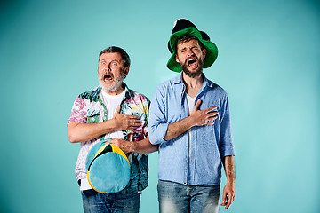 Image showing The two football fans singing the national anthem over blue