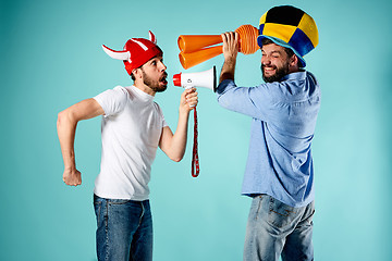 Image showing The two football fans with mouthpiece over blue