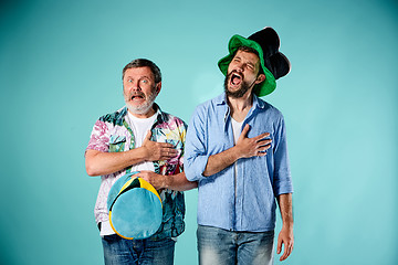 Image showing The two football fans singing the national anthem over blue