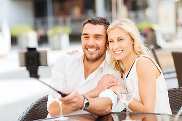 Image showing happy couple taking selfie with smartphone at cafe