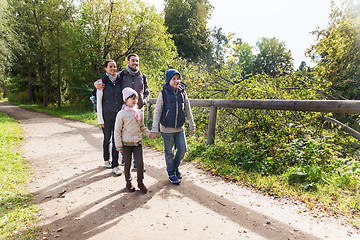 Image showing happy family with backpacks hiking in woods