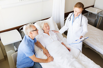 Image showing senior woman and doctor with clipboard at hospital