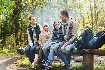 Image showing happy family sitting on bench and talking at camp