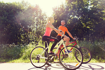 Image showing happy couple riding bicycle outdoors