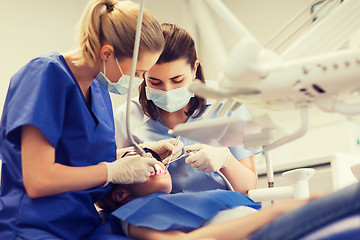 Image showing female dentists treating patient girl teeth