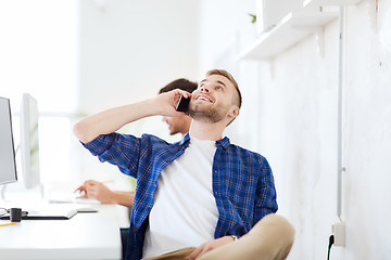Image showing happy creative man calling on cellphone at office
