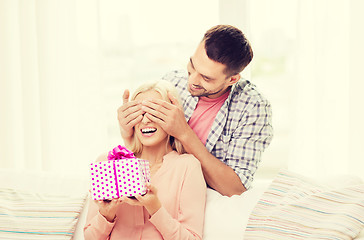 Image showing happy man giving woman gift box at home