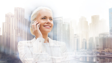 Image showing smiling businesswoman with smartphone outdoors