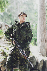 Image showing young soldier or hunter with gun in forest