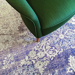 Image showing Green armchair on blue retro style carpet