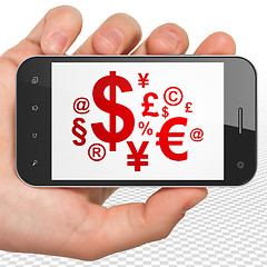 Image showing Business concept: Hand Holding Smartphone with Finance Symbol on display